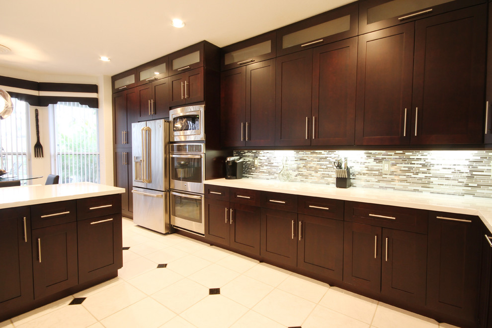 Example of a trendy l-shaped eat-in kitchen design in Miami with an undermount sink, shaker cabinets, brown cabinets, quartzite countertops, metallic backsplash and stainless steel appliances