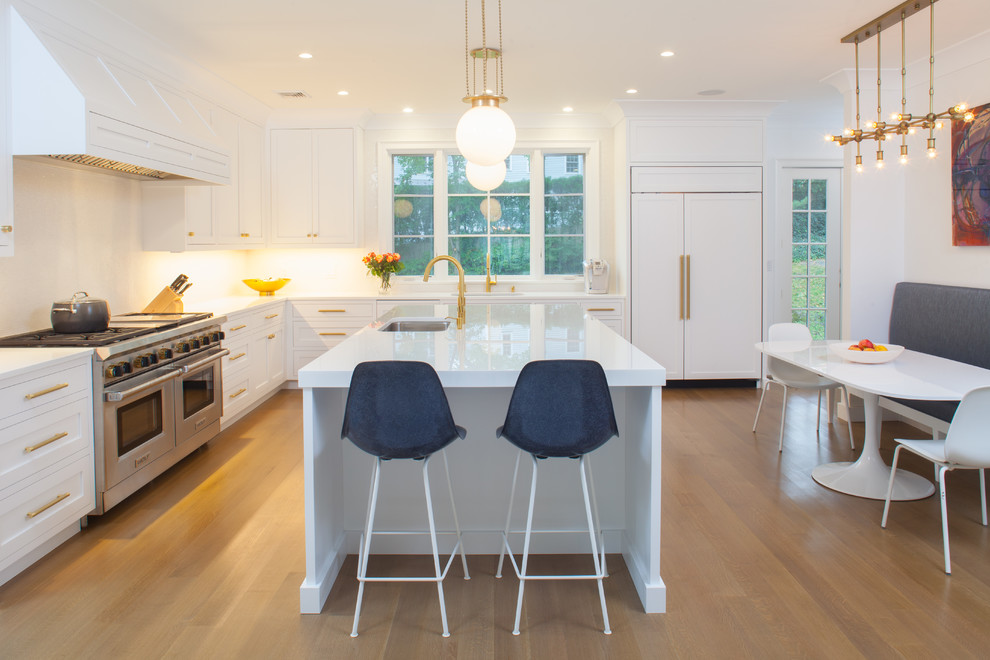Example of a large trendy u-shaped light wood floor enclosed kitchen design in New York with an undermount sink, recessed-panel cabinets, white cabinets, glass countertops, white backsplash, mosaic tile backsplash, paneled appliances and an island