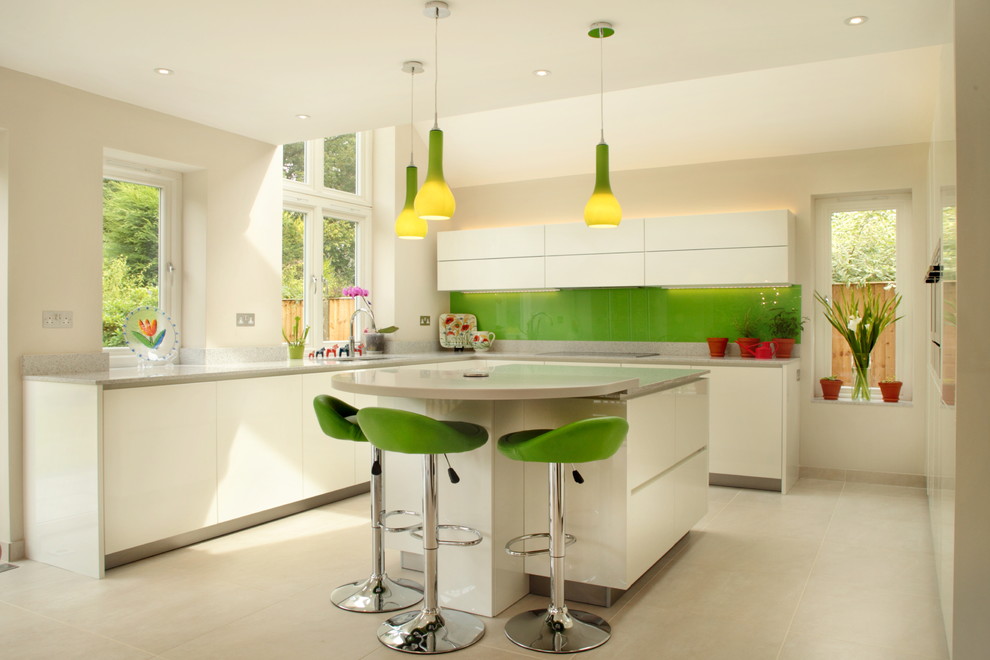 Large trendy u-shaped kitchen photo in Buckinghamshire with an undermount sink, flat-panel cabinets, white cabinets, green backsplash, glass sheet backsplash and an island