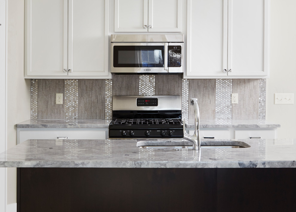 Foto di una grande cucina minimal chiusa con lavello sottopiano, ante con riquadro incassato, ante bianche, elettrodomestici in acciaio inossidabile e top in granito
