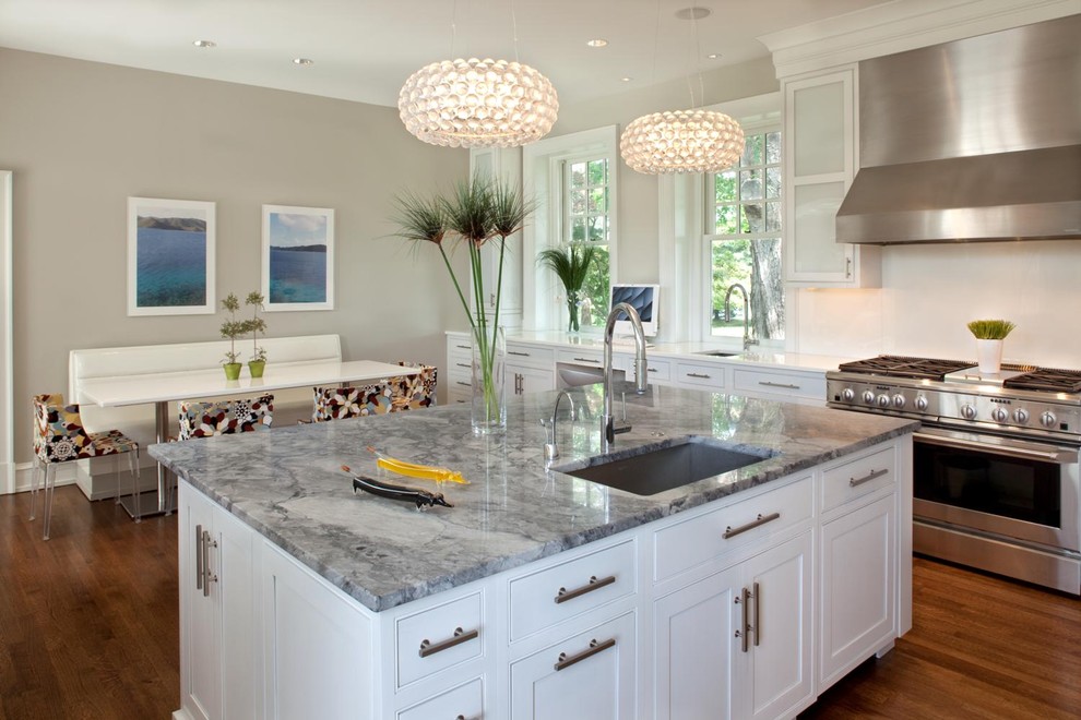 This is an example of a contemporary kitchen/diner in Philadelphia with stainless steel appliances, a single-bowl sink, beaded cabinets, white cabinets and marble worktops.