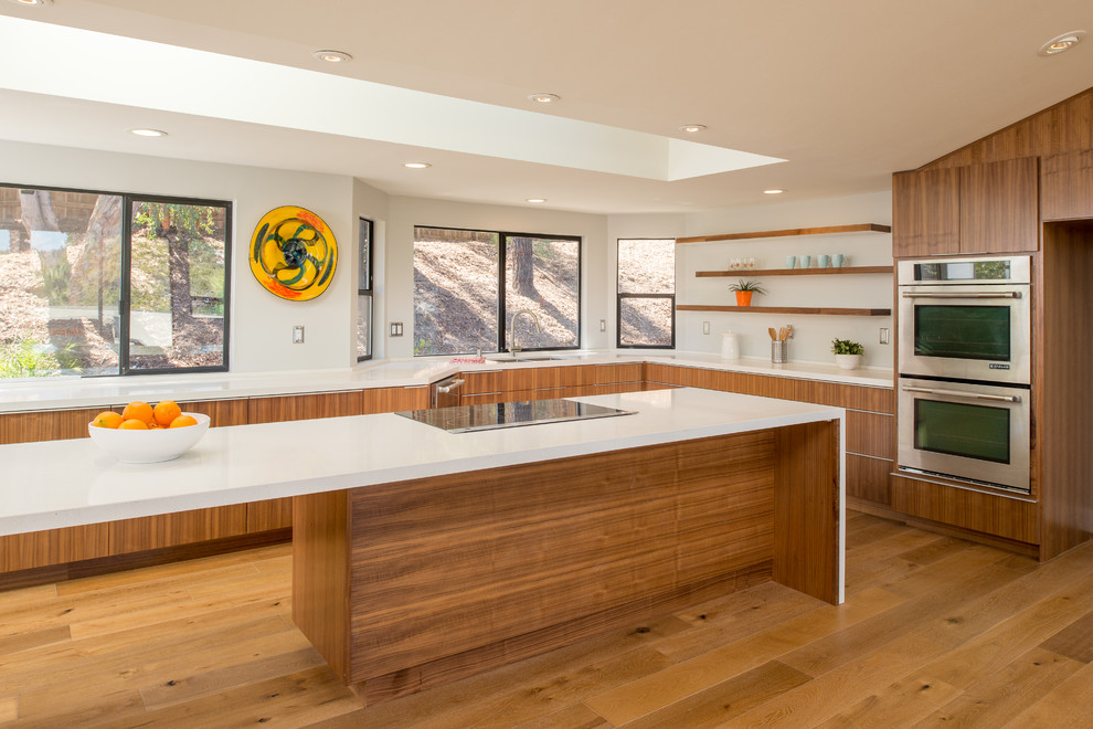 Open concept kitchen - large contemporary u-shaped medium tone wood floor open concept kitchen idea in San Diego with an undermount sink, flat-panel cabinets, dark wood cabinets, quartz countertops, white backsplash, stainless steel appliances and an island