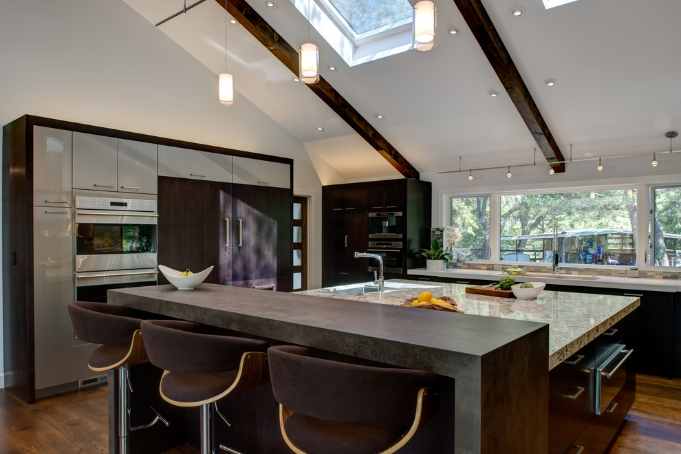 Design ideas for an expansive contemporary l-shaped kitchen/diner in San Francisco with a submerged sink, flat-panel cabinets, dark wood cabinets, engineered stone countertops, blue splashback, mosaic tiled splashback, stainless steel appliances, dark hardwood flooring and an island.