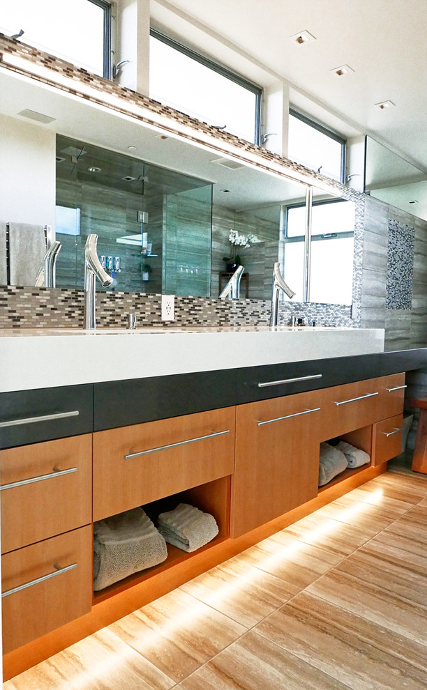 This is an example of a medium sized contemporary galley kitchen/diner in Los Angeles with a submerged sink, flat-panel cabinets, medium wood cabinets, granite worktops, metallic splashback, mirror splashback, stainless steel appliances, ceramic flooring, an island and beige floors.