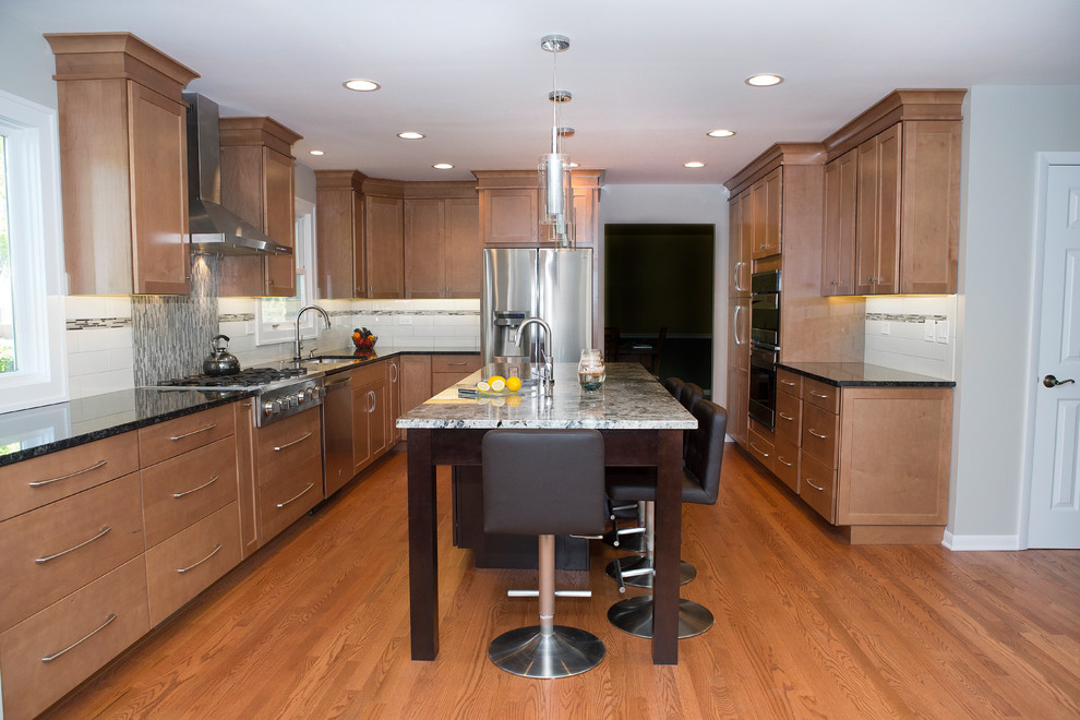 Large trendy u-shaped light wood floor eat-in kitchen photo in Chicago with a single-bowl sink, shaker cabinets, medium tone wood cabinets, granite countertops, beige backsplash, matchstick tile backsplash, stainless steel appliances and an island