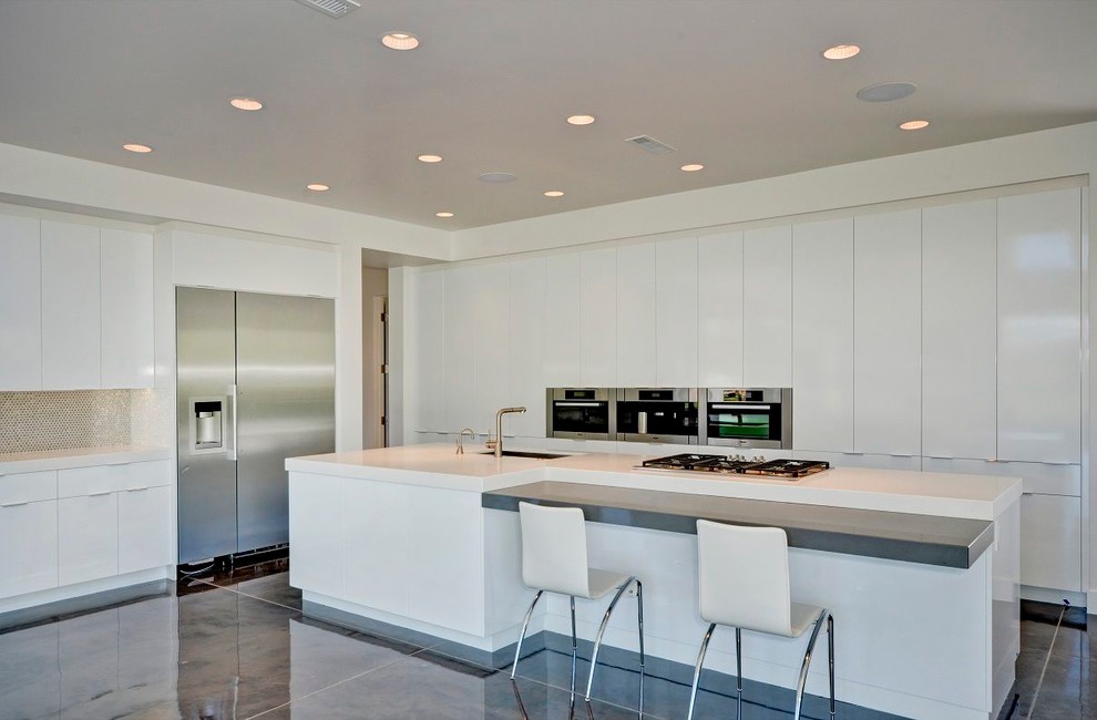 Imagen de cocina contemporánea con armarios con paneles lisos, puertas de armario blancas y electrodomésticos de acero inoxidable