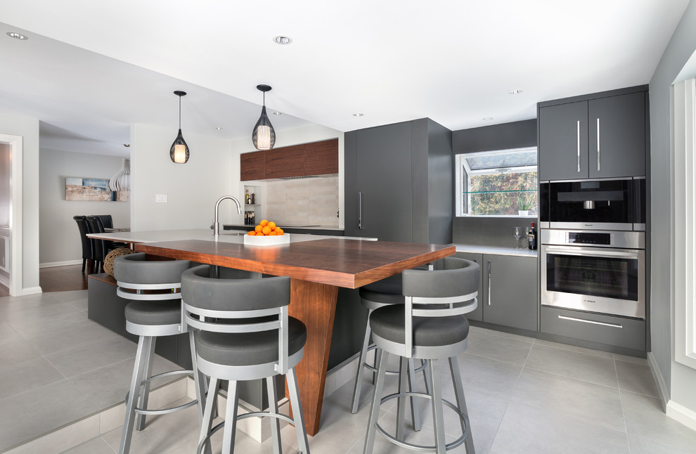 Moderne Küche mit Unterbauwaschbecken, flächenbündigen Schrankfronten, grauen Schränken, Küchenrückwand in Beige, Küchengeräten aus Edelstahl, Kücheninsel, grauem Boden und weißer Arbeitsplatte in Ottawa