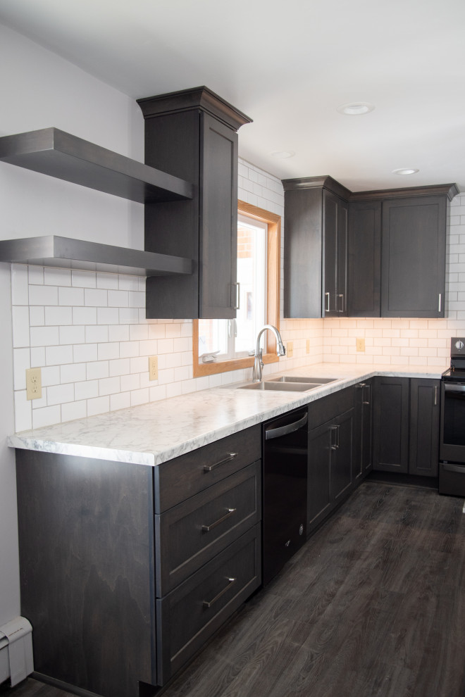 This is an example of a medium sized modern u-shaped kitchen/diner in Other with a built-in sink, flat-panel cabinets, dark wood cabinets, laminate countertops, white splashback, metro tiled splashback, black appliances, vinyl flooring, an island, grey floors and white worktops.