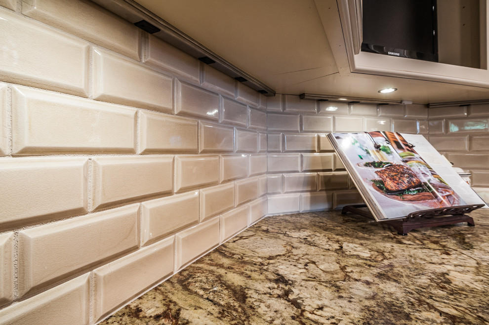 Elegant u-shaped open concept kitchen photo in Tampa with an undermount sink, raised-panel cabinets, beige cabinets, granite countertops, white backsplash, subway tile backsplash and paneled appliances