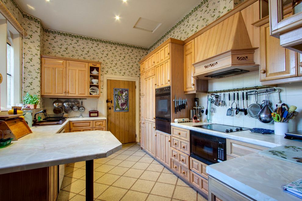 サリーにあるトラディショナルスタイルのおしゃれなコの字型キッチン (レイズドパネル扉のキャビネット、中間色木目調キャビネット、白いキッチンパネル) の写真