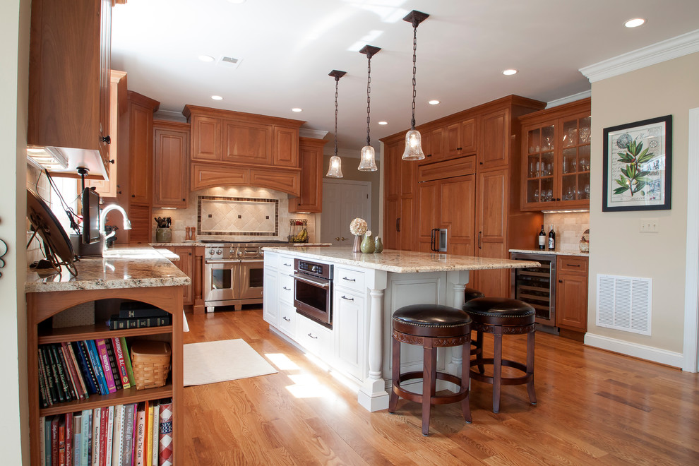 This is an example of a traditional u-shaped kitchen in DC Metro with a submerged sink, raised-panel cabinets, white cabinets, granite worktops, beige splashback and stainless steel appliances.