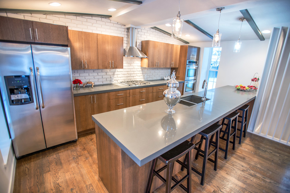 Inspiration for a 1950s single-wall eat-in kitchen remodel in Salt Lake City with an undermount sink, flat-panel cabinets, brown cabinets, quartz countertops, beige backsplash and stainless steel appliances