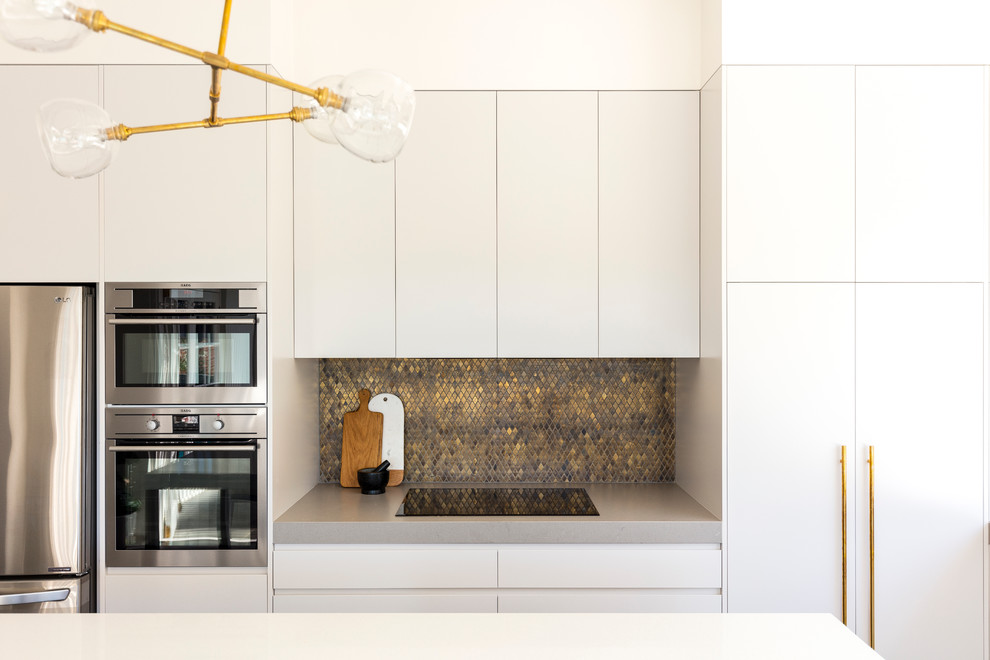 Inspiration for a medium sized contemporary l-shaped kitchen/diner in Sydney with a double-bowl sink, open cabinets, white cabinets, engineered stone countertops, metallic splashback, mosaic tiled splashback, stainless steel appliances, slate flooring and an island.