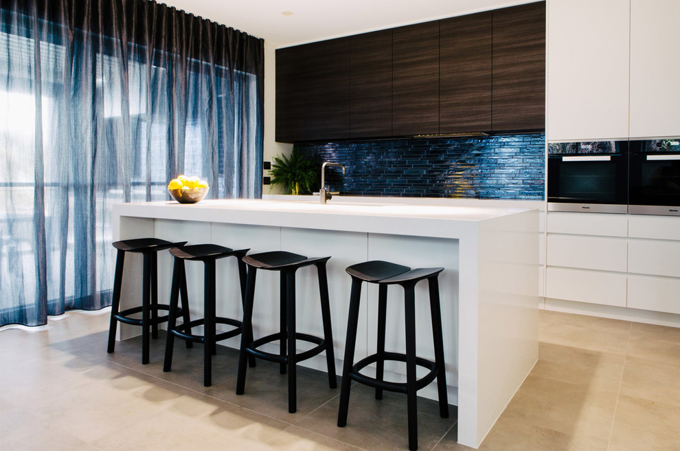 Offene, Einzeilige Moderne Küche mit flächenbündigen Schrankfronten, weißen Schränken, Küchenrückwand in Blau, Rückwand aus Stäbchenfliesen, Küchengeräten aus Edelstahl, Betonboden, Kücheninsel und grauem Boden in Sydney