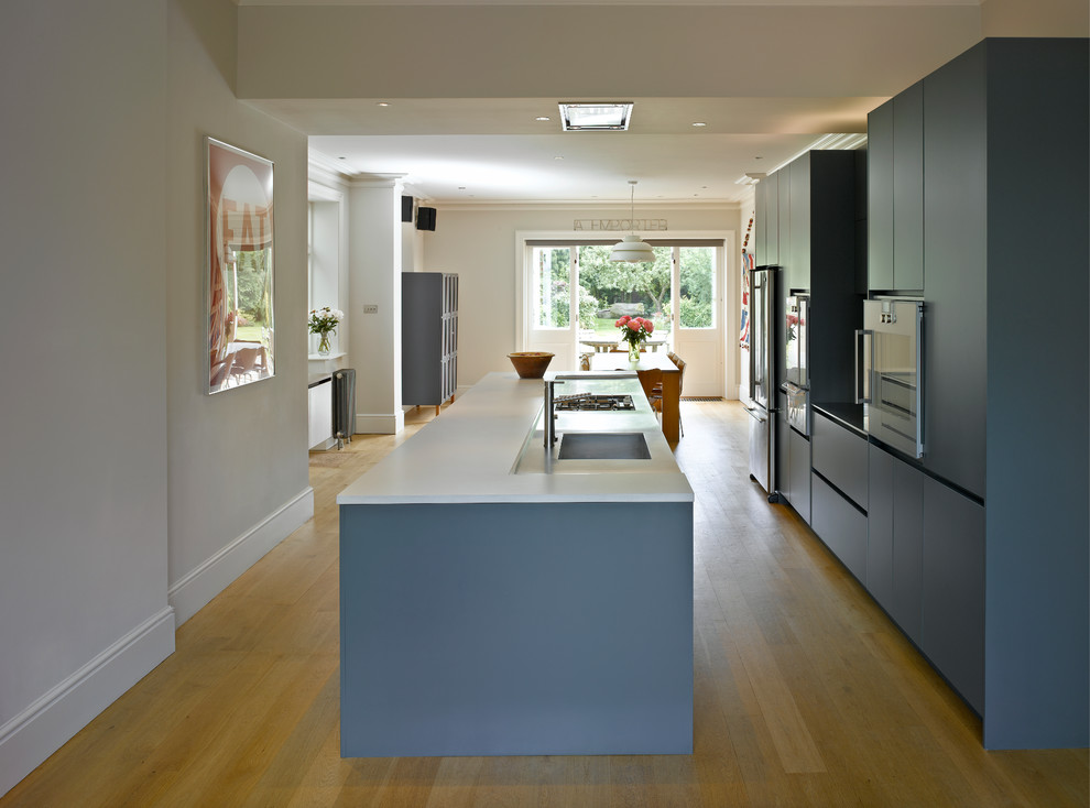 Exempel på ett stort modernt vit linjärt vitt kök och matrum, med släta luckor, blå skåp, marmorbänkskiva och en köksö
