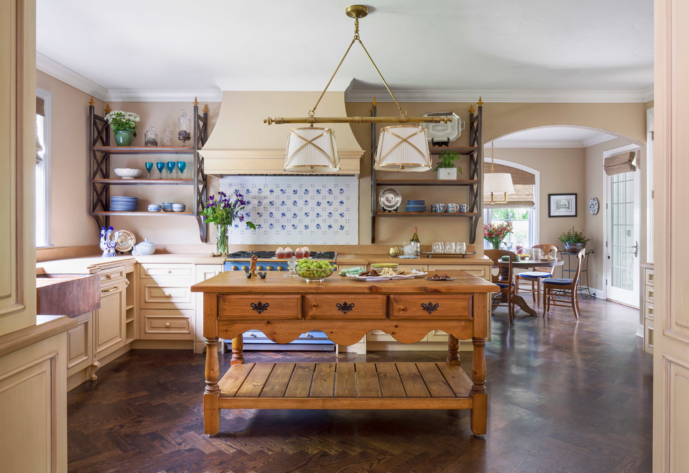 Klassische Küche in L-Form mit Landhausspüle, profilierten Schrankfronten, beigen Schränken, bunten Elektrogeräten, dunklem Holzboden, Kücheninsel, braunem Boden und beiger Arbeitsplatte in Denver