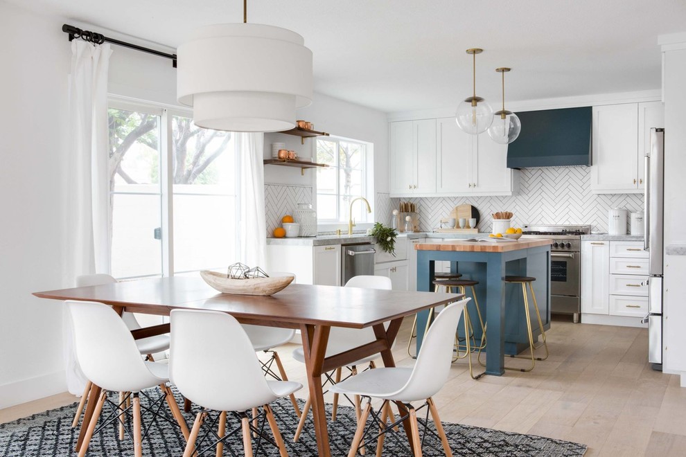Inspiration for a coastal u-shaped light wood floor and beige floor eat-in kitchen remodel in Providence with a farmhouse sink, shaker cabinets, white cabinets, white backsplash, ceramic backsplash, stainless steel appliances, an island and gray countertops