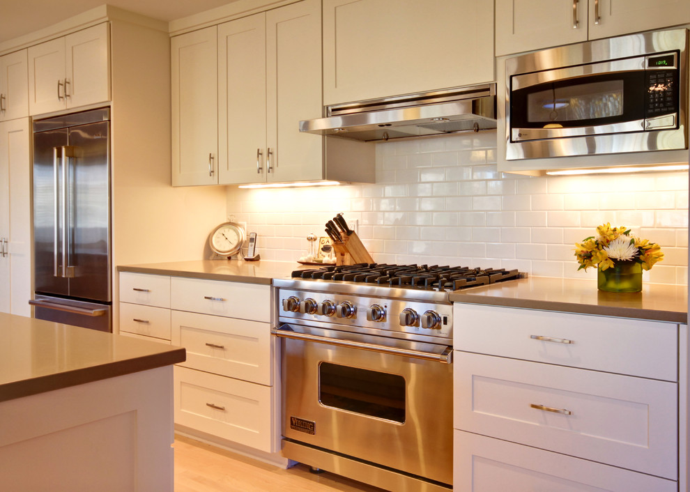 Moderne Küche mit Küchengeräten aus Edelstahl und Rückwand aus Metrofliesen in Minneapolis
