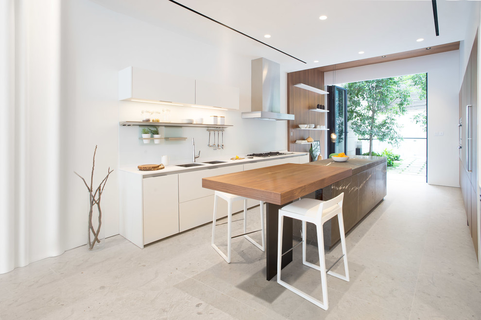 This is an example of a large modern galley kitchen in Hong Kong with a double-bowl sink, flat-panel cabinets, white cabinets, granite worktops, stainless steel appliances and an island.