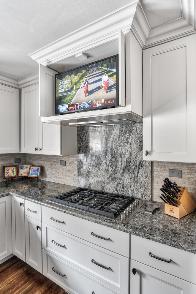 Eat-in kitchen - mid-sized traditional l-shaped dark wood floor eat-in kitchen idea in New York with an undermount sink, shaker cabinets, white cabinets, gray backsplash, stone tile backsplash, stainless steel appliances, an island and multicolored countertops