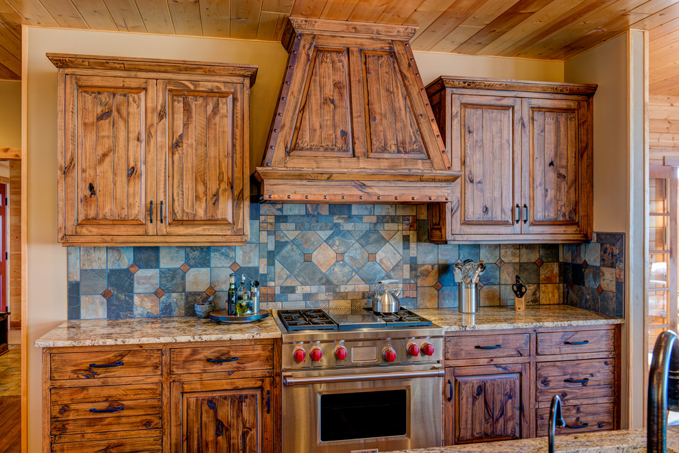 Idéer för mellanstora rustika kök, med luckor med upphöjd panel, skåp i mellenmörkt trä, granitbänkskiva, rostfria vitvaror, en köksö, mellanmörkt trägolv, brunt golv, grått stänkskydd och stänkskydd i skiffer
