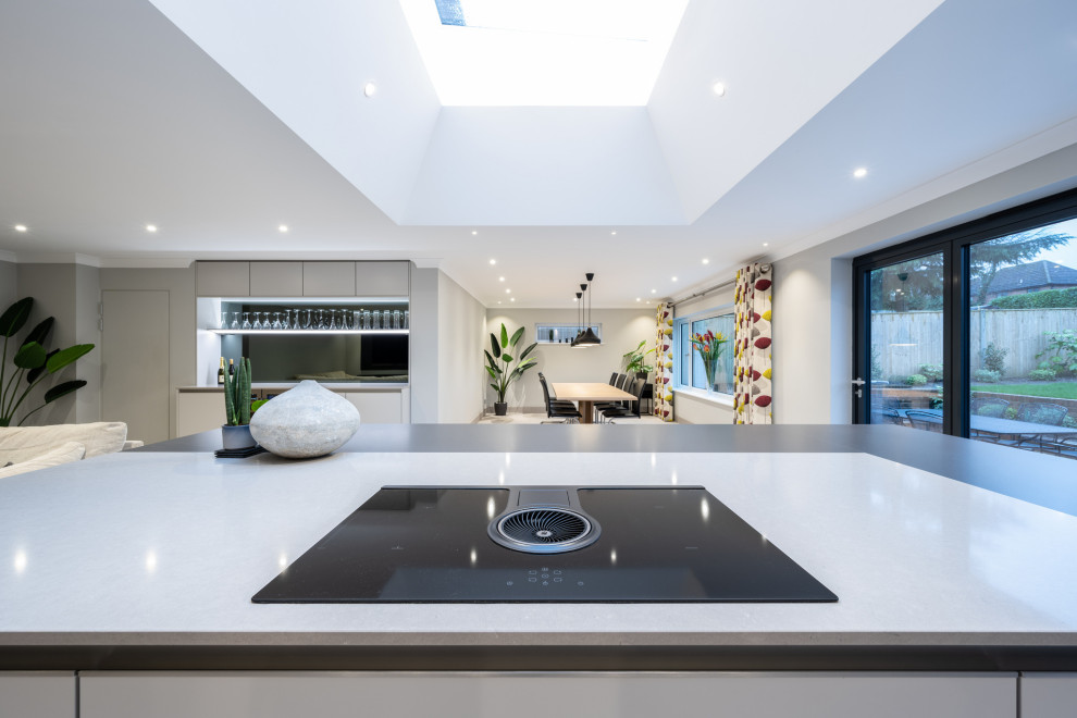 Große Moderne Küche mit flächenbündigen Schrankfronten und Kücheninsel in Surrey