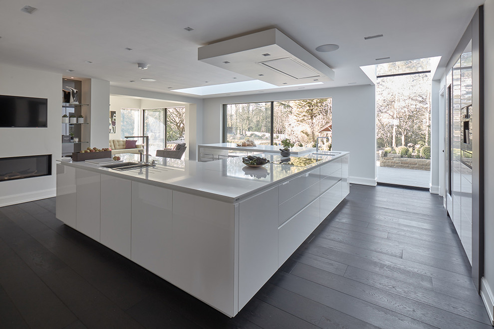 Inspiration for a large modern u-shaped open plan kitchen in Other with flat-panel cabinets, white cabinets, granite worktops, integrated appliances, dark hardwood flooring, an island and black floors.