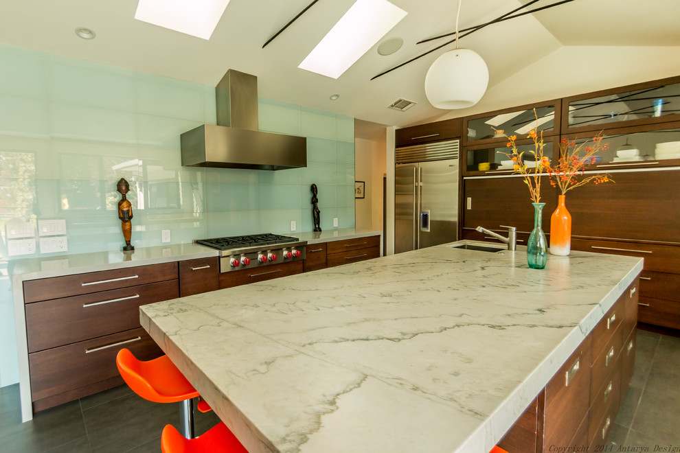 Idee per una cucina minimal di medie dimensioni con lavello sottopiano, ante lisce, ante in legno scuro, top in marmo, paraspruzzi con lastra di vetro e elettrodomestici in acciaio inossidabile