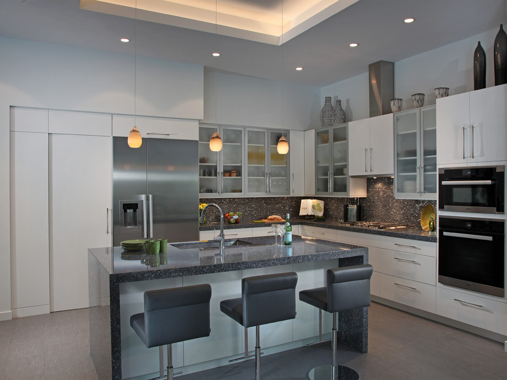 Eat-in kitchen - mid-sized contemporary l-shaped porcelain tile eat-in kitchen idea in Tampa with an undermount sink, flat-panel cabinets, white cabinets, quartzite countertops, multicolored backsplash, mosaic tile backsplash, stainless steel appliances and an island