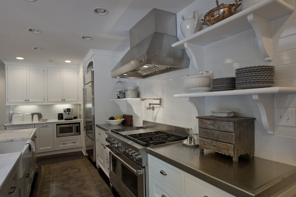 Moderne Küche mit Waschbecken, flächenbündigen Schrankfronten, weißen Schränken, Küchenrückwand in Weiß, Küchengeräten aus Edelstahl, dunklem Holzboden und Kücheninsel in Indianapolis