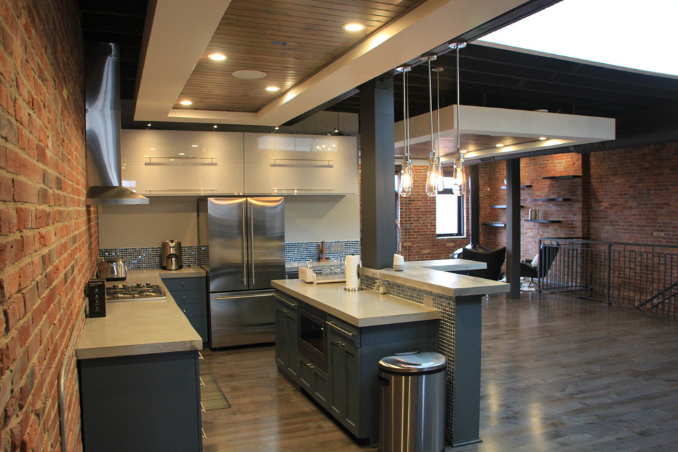 Example of a mid-sized trendy l-shaped medium tone wood floor and gray floor eat-in kitchen design in St Louis with a farmhouse sink, shaker cabinets, blue cabinets, concrete countertops, multicolored backsplash, brick backsplash, stainless steel appliances, an island and gray countertops