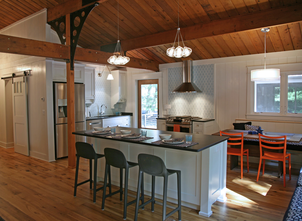 Eat-in kitchen - mid-sized industrial light wood floor eat-in kitchen idea in Milwaukee with a single-bowl sink, recessed-panel cabinets, white cabinets, granite countertops, blue backsplash, ceramic backsplash, stainless steel appliances and an island