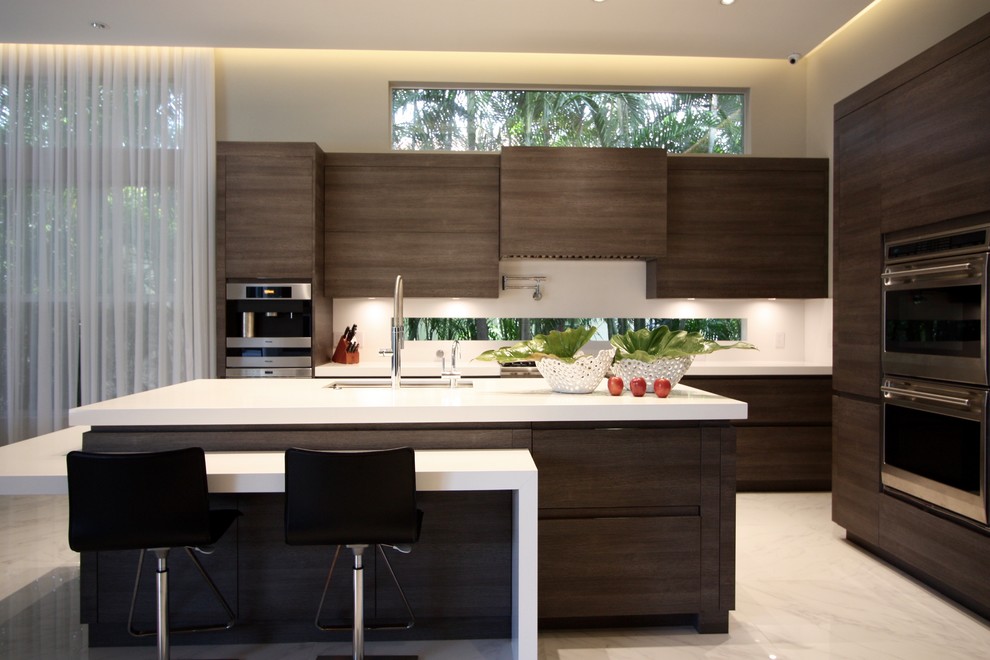 Exemple d'une cuisine ouverte tendance en L et bois foncé avec un placard à porte plane, un plan de travail en quartz, une crédence blanche, un électroménager en acier inoxydable, un sol en marbre et îlot.