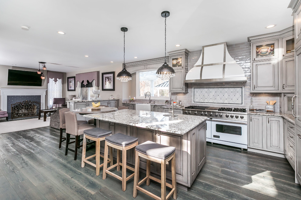 Inspiration for a large traditional u-shaped kitchen/diner in Baltimore with a belfast sink, beaded cabinets, grey cabinets, granite worktops, grey splashback, white appliances, medium hardwood flooring, an island and grey floors.
