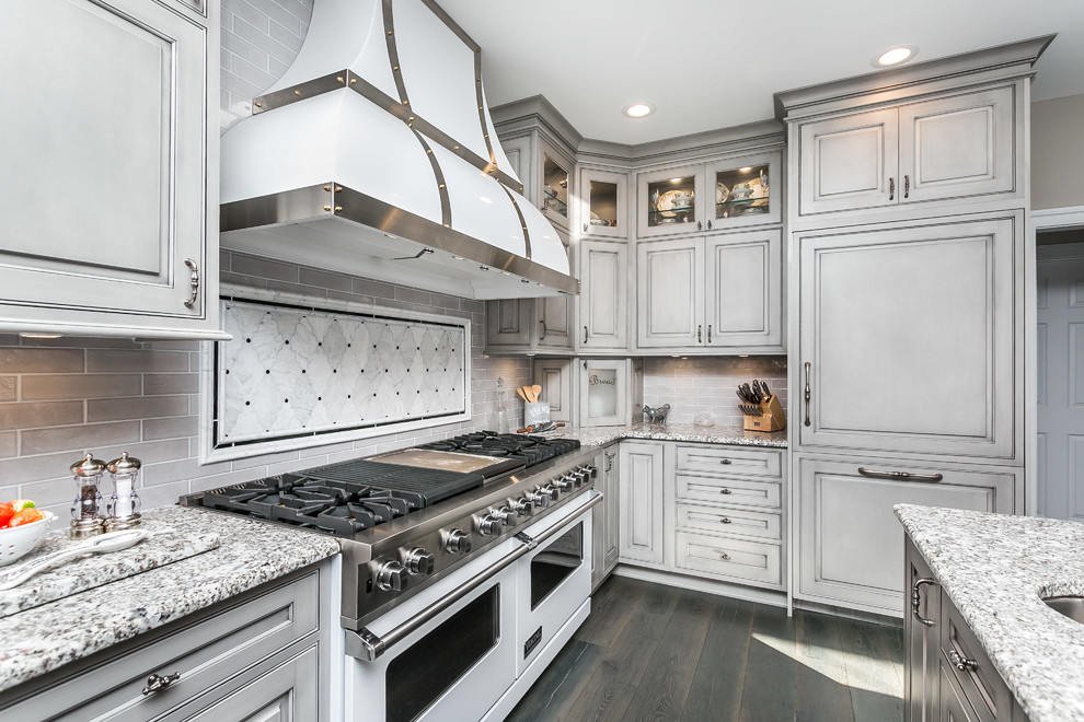Inspiration for a large traditional u-shaped kitchen/diner in Baltimore with a belfast sink, beaded cabinets, grey cabinets, granite worktops, grey splashback, white appliances, medium hardwood flooring, an island and grey floors.
