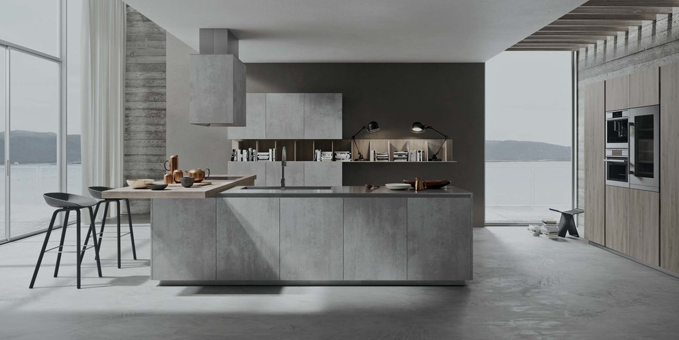 Example of a mid-sized minimalist galley concrete floor open concept kitchen design in New York with an undermount sink, flat-panel cabinets, gray cabinets, solid surface countertops, stainless steel appliances and an island