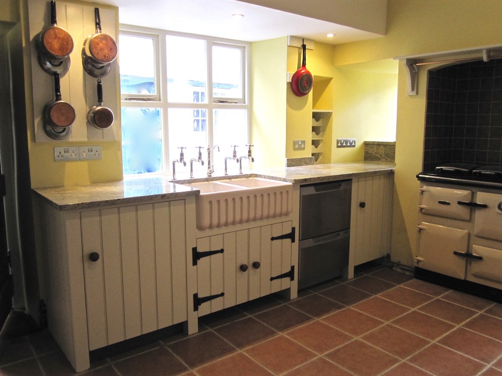 Eat-in kitchen - large transitional terra-cotta tile eat-in kitchen idea in Wiltshire with a farmhouse sink, beaded inset cabinets, granite countertops, white appliances and two islands