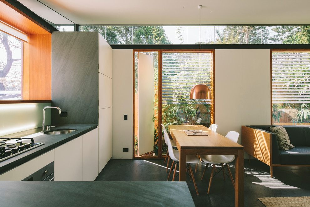 Offene Moderne Küche in L-Form mit flächenbündigen Schrankfronten, Unterbauwaschbecken, weißen Schränken und Halbinsel in Sydney