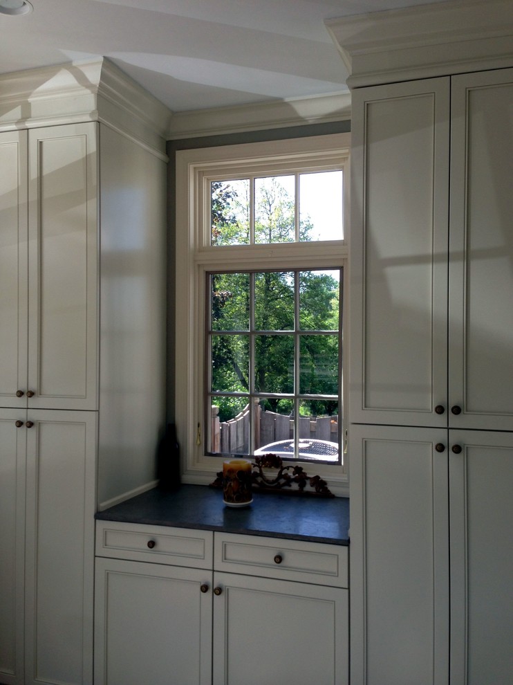 Immagine di una cucina classica di medie dimensioni con ante con bugna sagomata, ante bianche e top in granito