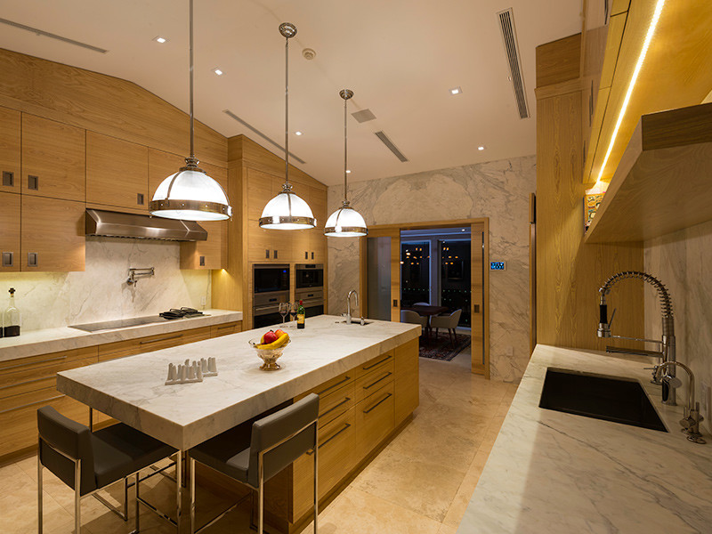 Bild på ett stort funkis kök, med en undermonterad diskho, släta luckor, skåp i ljust trä, marmorbänkskiva, vitt stänkskydd, stänkskydd i sten, rostfria vitvaror, travertin golv och en köksö