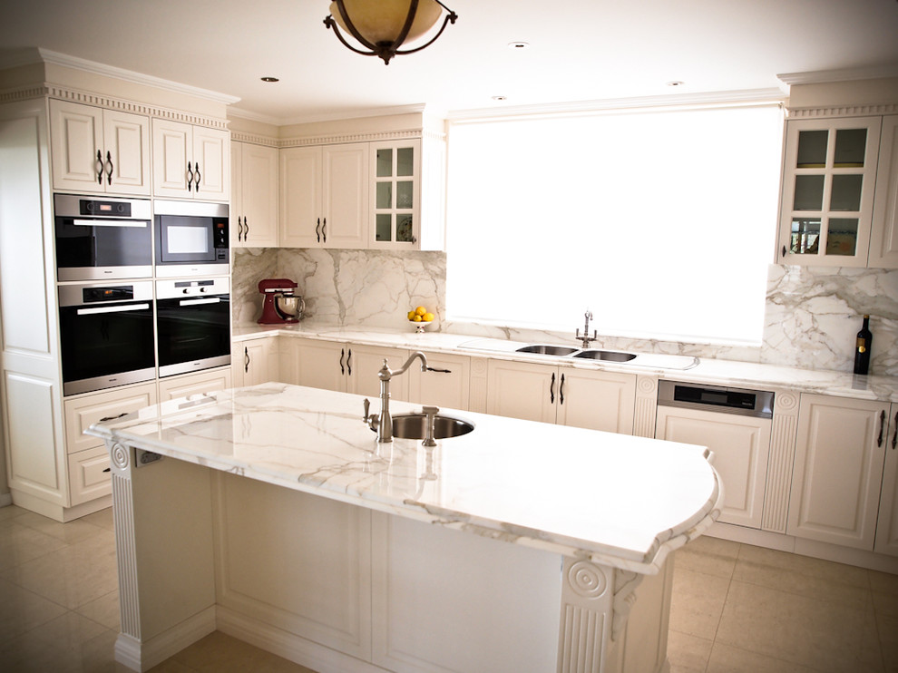 Bild på ett avskilt, stort lantligt u-kök, med en undermonterad diskho, vita skåp, marmorbänkskiva, rostfria vitvaror, klinkergolv i porslin, en köksö, skåp i shakerstil och stänkskydd i sten