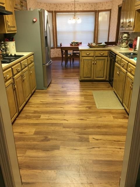 This is an example of a small classic galley enclosed kitchen in Other with a submerged sink, stainless steel appliances, medium hardwood flooring and no island.