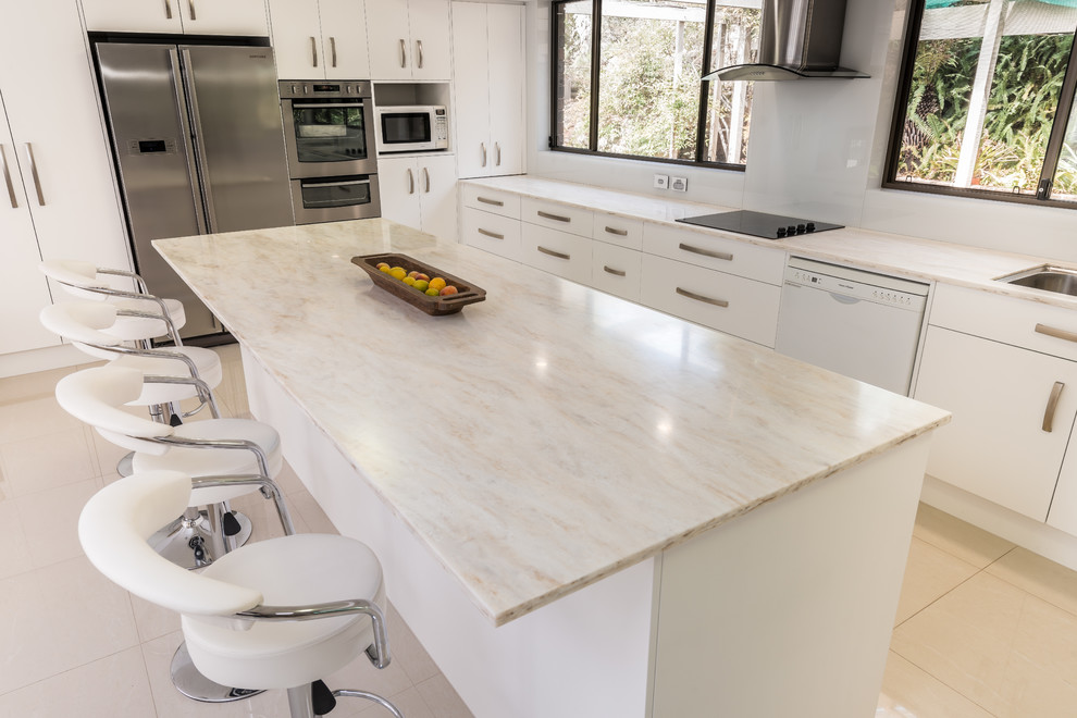 Inspiration for a large contemporary porcelain tile eat-in kitchen remodel in Other with an undermount sink, white cabinets, solid surface countertops, white backsplash, glass sheet backsplash, stainless steel appliances and an island
