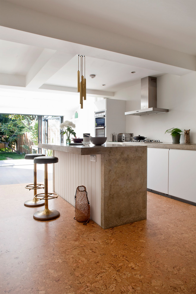 Idee per una grande cucina design con ante lisce, ante bianche, elettrodomestici in acciaio inossidabile, pavimento arancione e top beige
