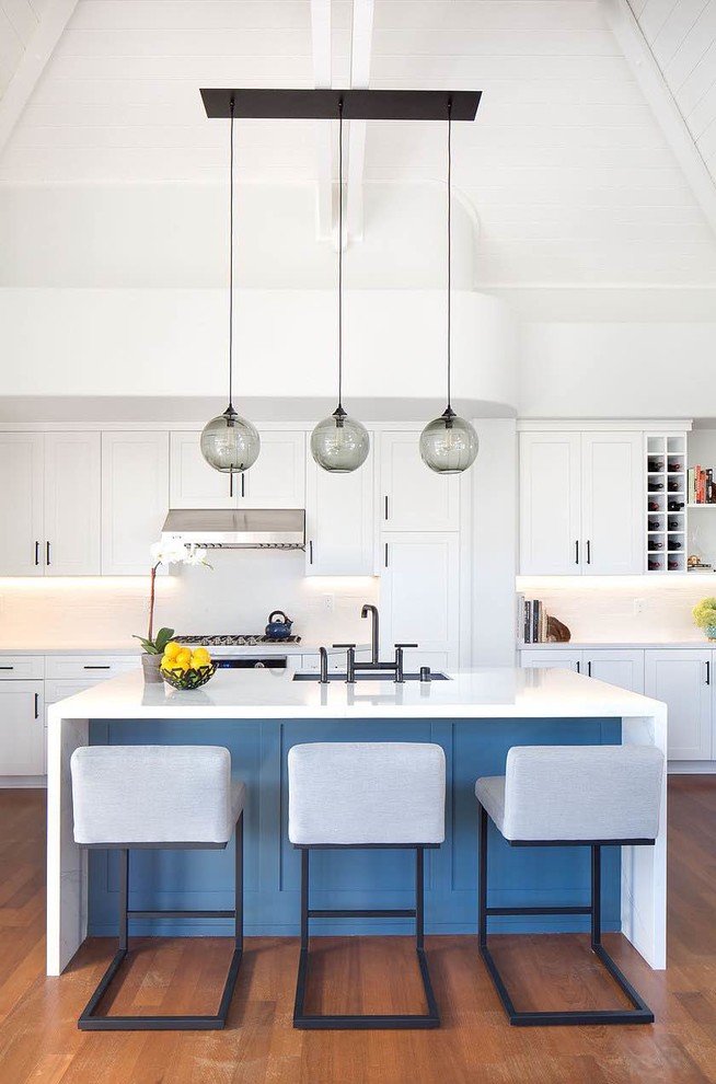 Klassische Küche mit Unterbauwaschbecken, Schrankfronten im Shaker-Stil, weißen Schränken, Küchenrückwand in Weiß, braunem Holzboden, Kücheninsel und orangem Boden in Orange County