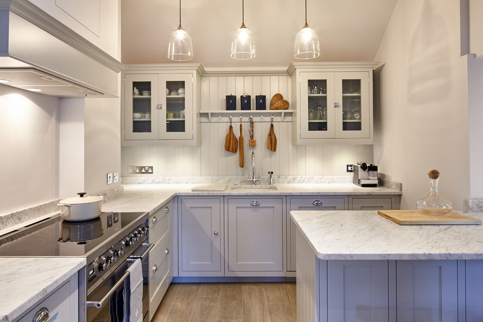 Immagine di una cucina a L chic di medie dimensioni con lavello sottopiano, ante in stile shaker, top in marmo, paraspruzzi bianco e penisola