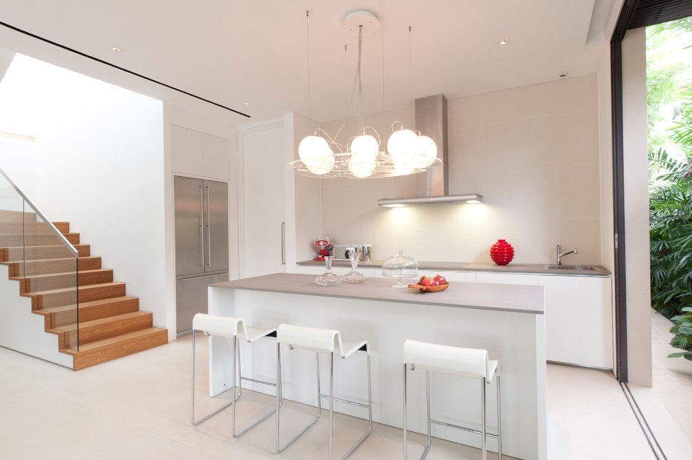 Источник вдохновения для домашнего уюта: параллельная кухня в стиле модернизм с плоскими фасадами, белыми фасадами и серым фартуком