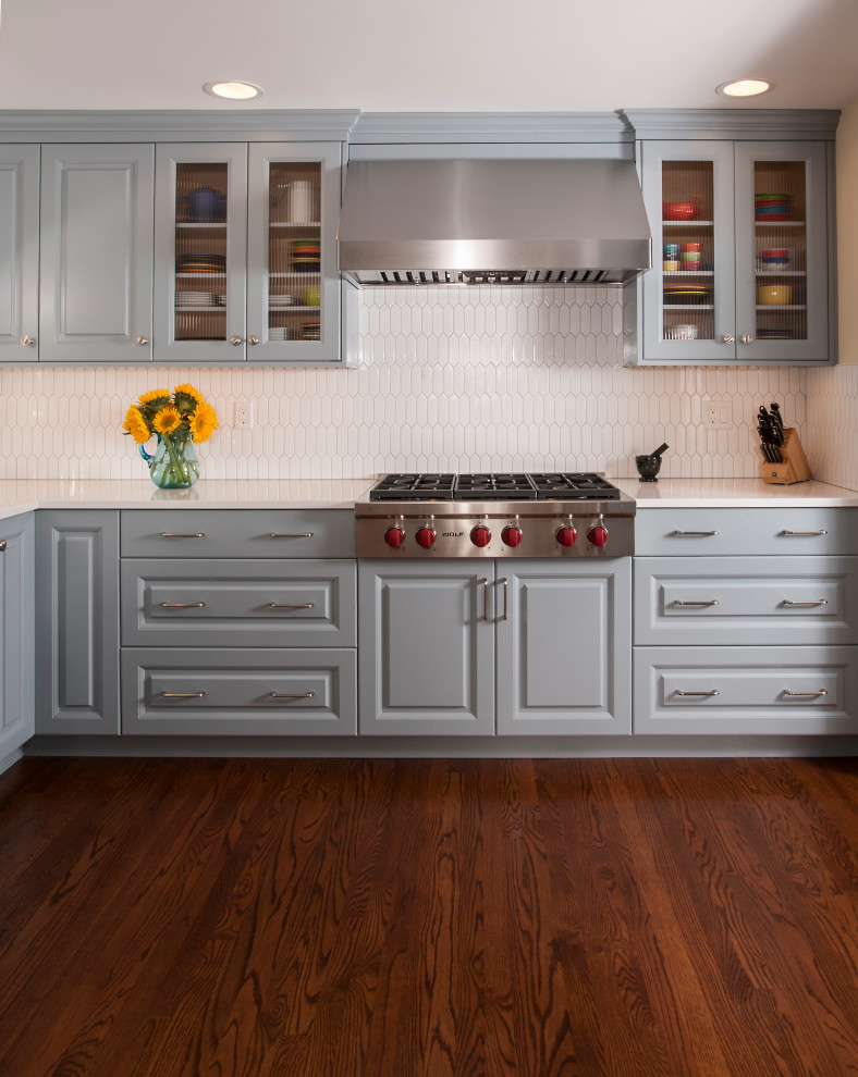 Exempel på ett mellanstort klassiskt vit vitt kök, med en undermonterad diskho, luckor med upphöjd panel, blå skåp, bänkskiva i kvarts, vitt stänkskydd, stänkskydd i keramik, rostfria vitvaror, mörkt trägolv och brunt golv
