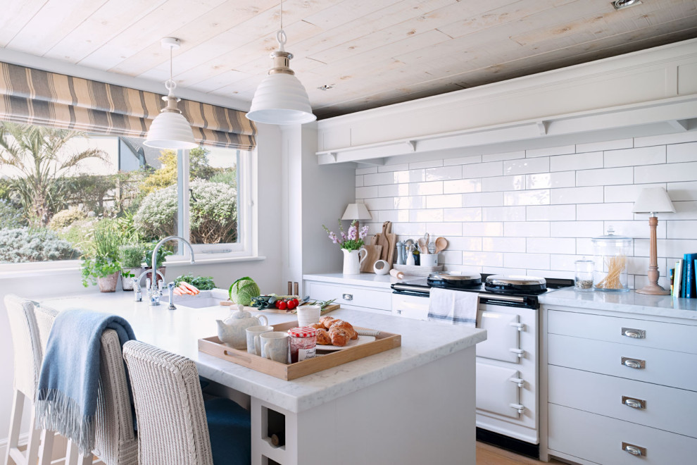 This is an example of a nautical galley kitchen in Other with grey cabinets, white splashback, ceramic splashback, white appliances, medium hardwood flooring, brown floors, white worktops, a submerged sink, flat-panel cabinets and a breakfast bar.