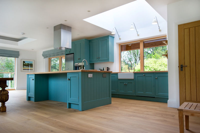 Inspiration for a large beach style kitchen/diner in Cornwall with a submerged sink, blue cabinets, wood worktops, stainless steel appliances, medium hardwood flooring and an island.